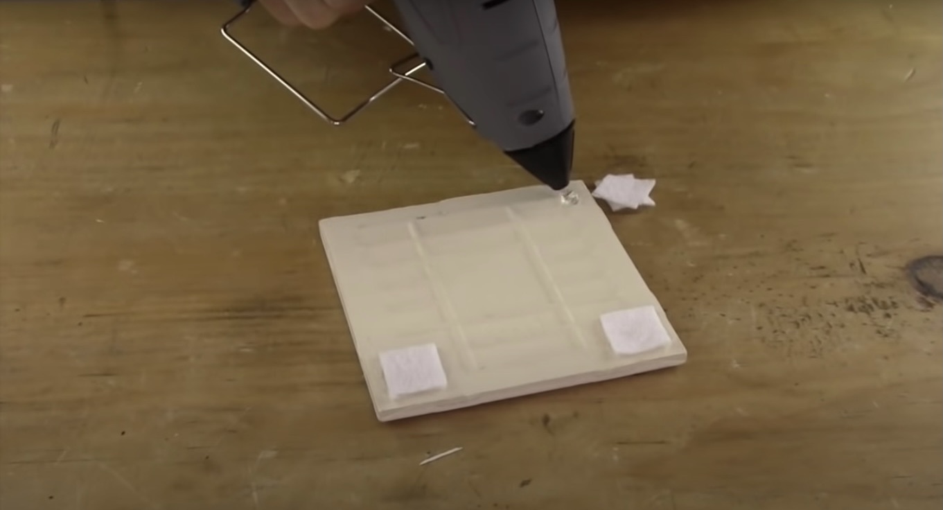 this photo shows how to hot glue felt corners on the bottom of your DIY photo coasters