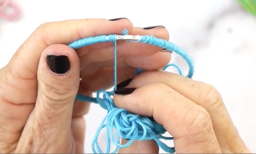 This is a DIY Bracelet tutorial to make bracelets using embroidery thread. This is the third step in the process.  Glue the end of your embroidery floss to the silver bangle bracelet.